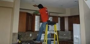 Water Damage Restoration Tech Cleaning Mold Off Ceiling